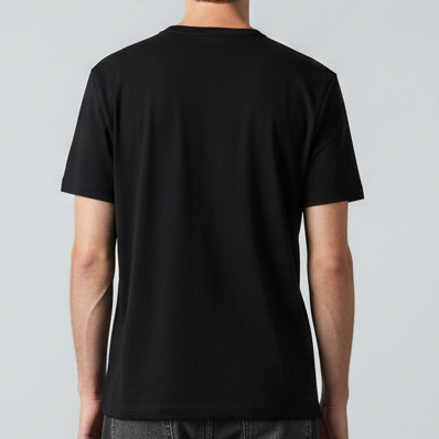Person wearing a black t-shirt and gray pants standing against a plain background