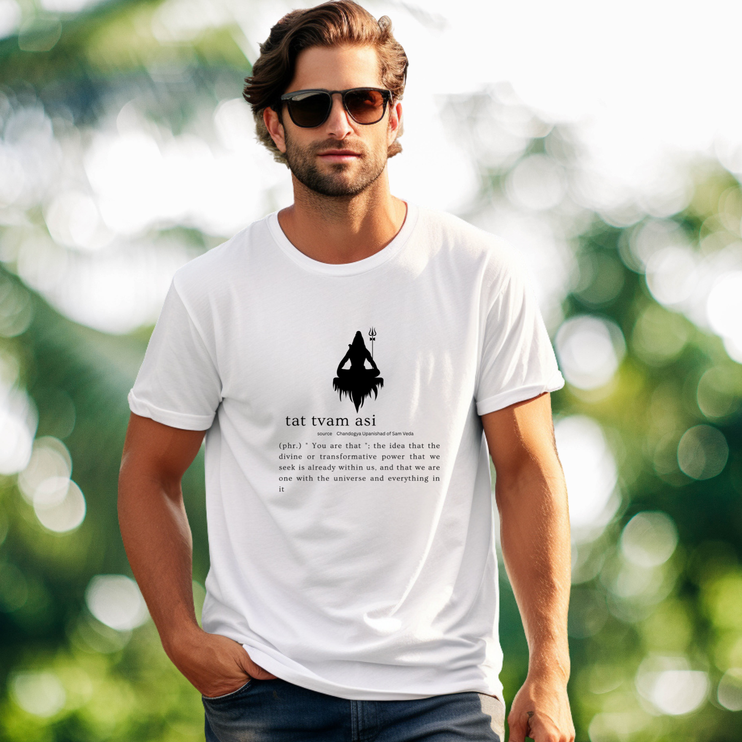 Man wearing a white t-shirt with a graphic design and text, standing outdoors with a blurred green background.