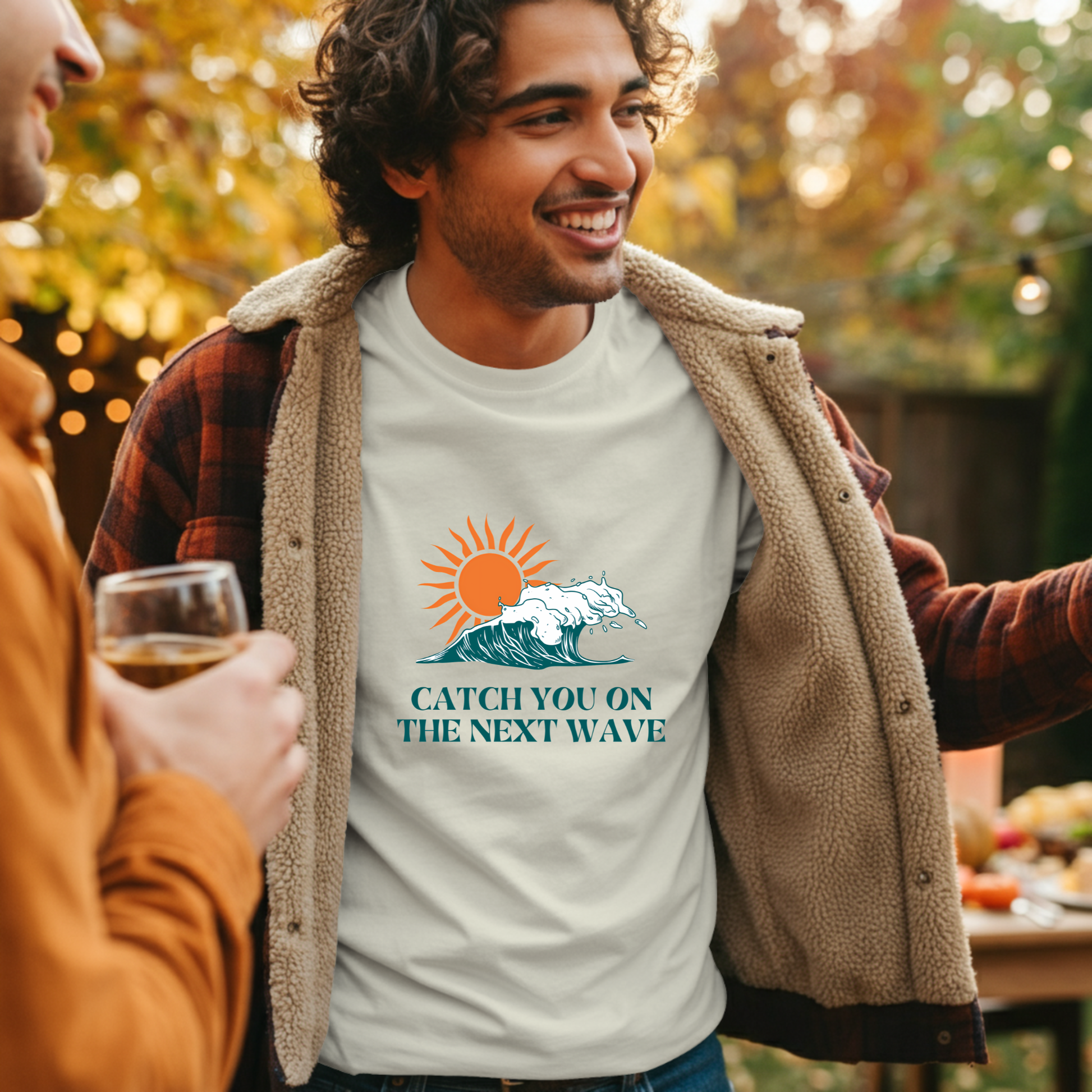 Man wearing a t-shirt with a graphic design and text, standing outdoors with another person.