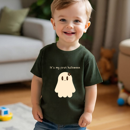 Child wearing a green t-shirt with a ghost graphic and text, standing in a living room.