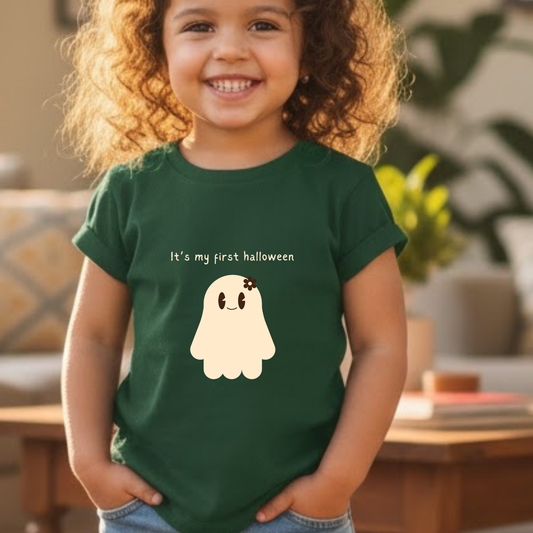 Child wearing a green t-shirt with a ghost graphic and text, standing in a home setting.