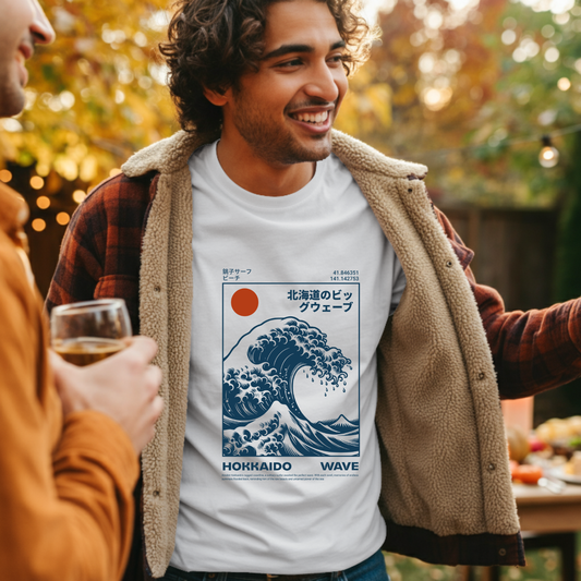 Man wearing a t-shirt with a wave design and text, standing outdoors with another person.