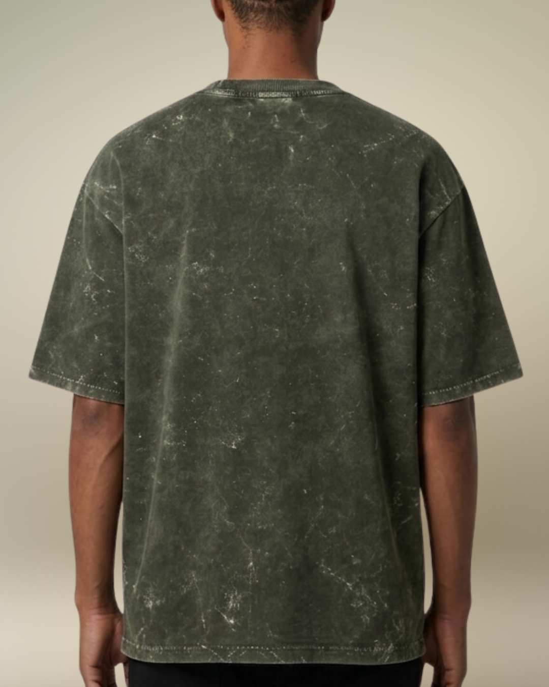 Person wearing a green marble-patterned t-shirt against a beige background