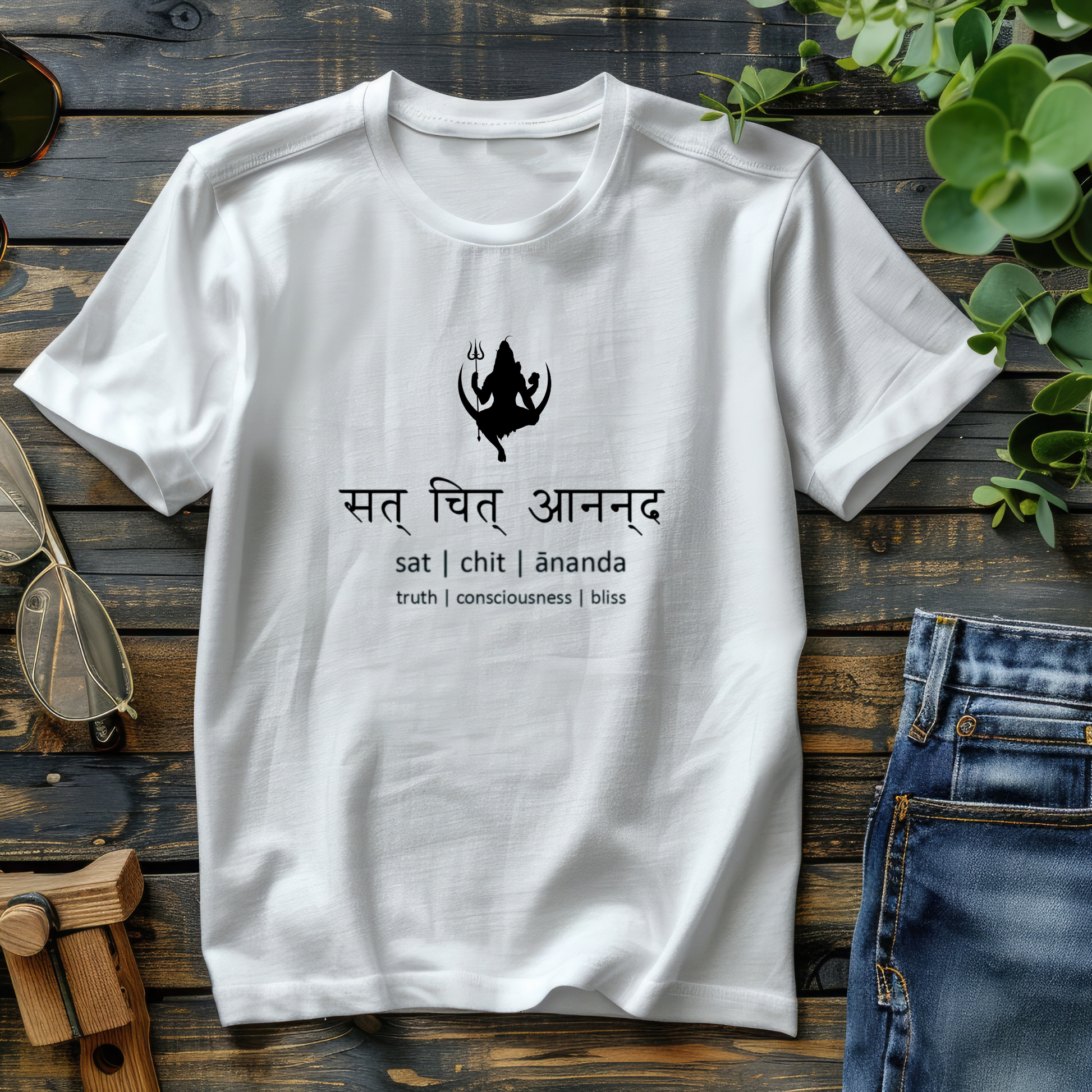 White t-shirt with black graphic and text on a wooden surface with jeans and plant