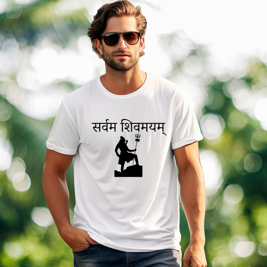 Man wearing a white t-shirt with black text and symbol, standing outdoors with a blurred green background