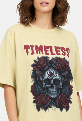 Woman wearing a yellow t-shirt with a skull and roses design and 'TIMELESS' text.