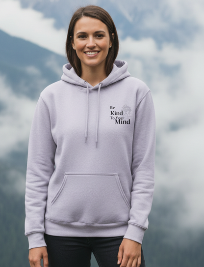 Woman wearing a light purple hoodie with text against a mountainous background