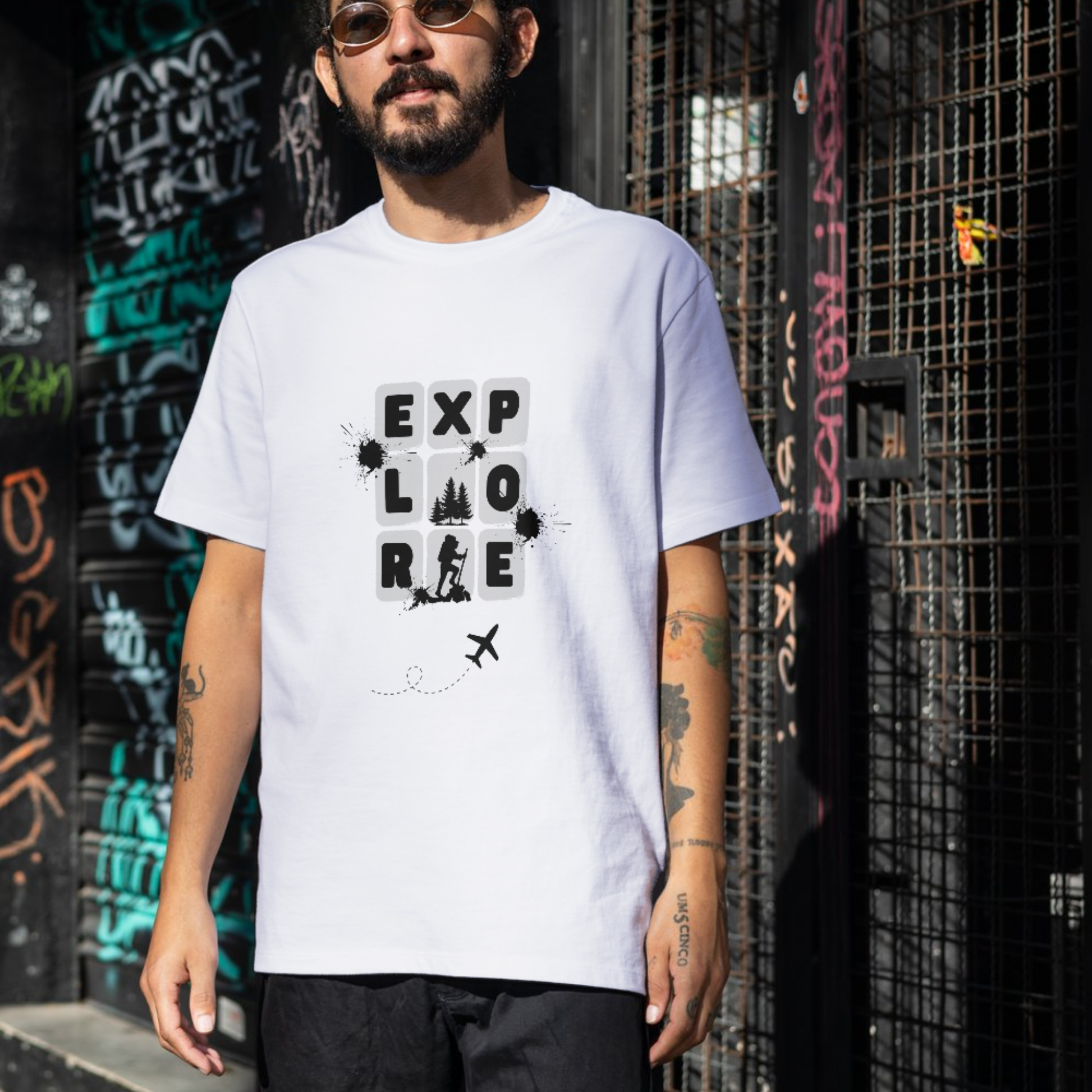 Man wearing a white t-shirt with 'EXPLORE' graphic design in an urban setting.