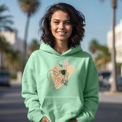 Woman wearing a light green hoodie with a floral design outdoors.