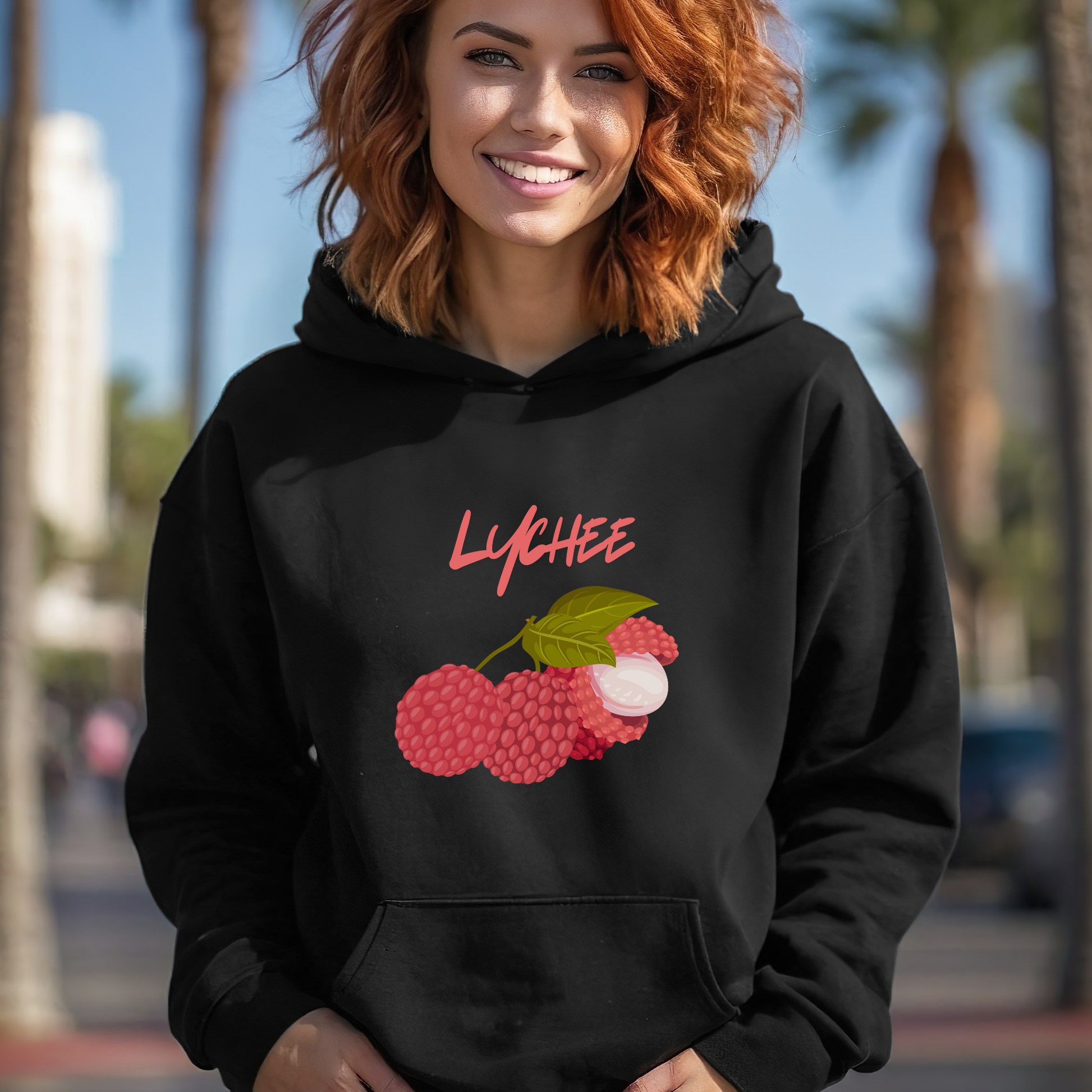 Person wearing a black hoodie with lychee design outdoors